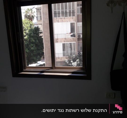 חלון אלומיניום עם נוף לבניין ממול